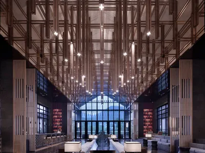 現代酒店大廳以混凝土與木質材料打造，搭配高挑天花板與大型落地窗。