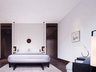 A minimalist bedroom featuring wood, leather, and metal materials.