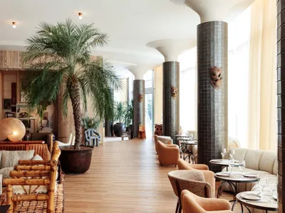 A modern restaurant lounge with wooden furniture, ceramic tile accents, and upholstered seating.