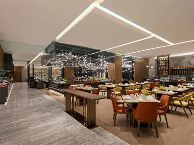 明亮的現代酒店早餐區，搭配木質地板與玻璃天花板。