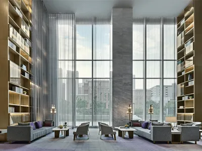 Modern hotel lobby featuring large glass windows overlooking a cityscape