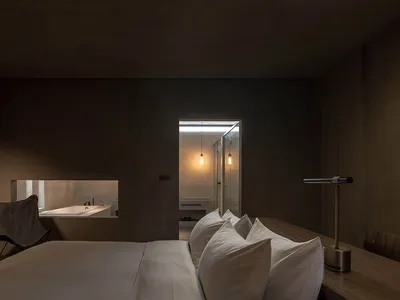 Well-designed, modern hotel room interior with a concrete floor and minimalist furniture.