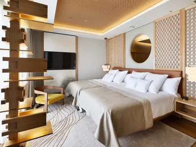 Modern hotel room with a wooden lattice accent wall, white bedding, and a large window allowing natural light to flood in.