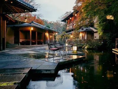 Outdoor seating area of a Japanese restaurant with natural stone floors, wooden railings, and lanterns.