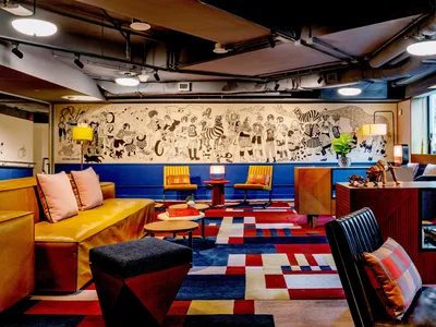 Modern hotel lounge featuring colorful carpet pattern and various seating arrangements.