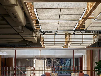 A modern hotel lobby featuring multiple seating areas with a mix of materials including leather, wood, and fabric.