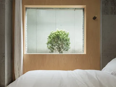 簡約臥室內設有混凝土特色牆與床鋪。