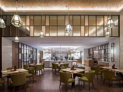 Dining and bar area of a modern restaurant with tables, chairs, and a service counter.