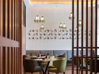 Modern restaurant interior featuring wooden accents, leather seating, and ceramic wall decor
