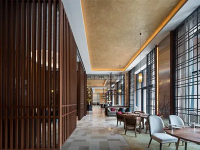 Modern restaurant interior featuring a combination of wooden slatted walls and stone-tiled floors.