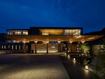 A modern resort entrance featuring a wooden canopy structure and concrete elements.