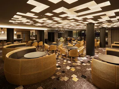 Interior design of a modern cafe bar with wicker furniture and geometric ceiling lights.