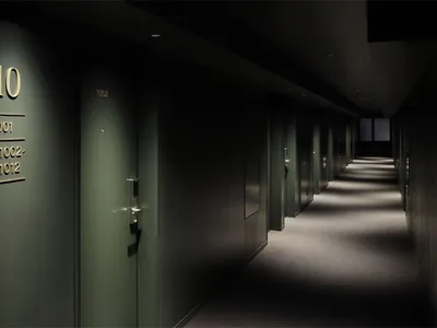 Modern metal hotel corridor with numbered doors and professional lighting
