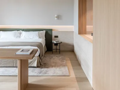 Minimalist bedroom featuring wood and concrete materials