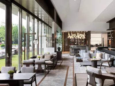 A modern hotel lobby featuring industrial lighting and contemporary design elements.