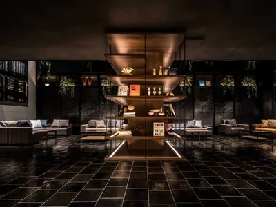 A minimalist hotel lobby with wooden shelves, glass and concrete elements.