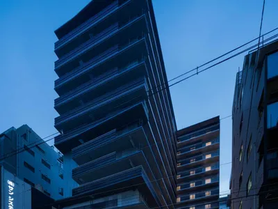 A modern, modular hotel front with dark metal-clad boards.