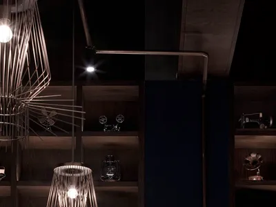 A modern restaurant bar setting with metal pendant lights, wooden shelves, and leather seating.