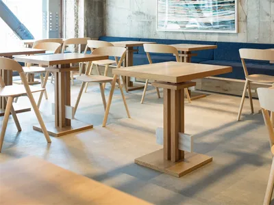 Modern restaurant interior design with wooden furniture and blue seating.