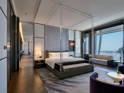 A modern hotel suite featuring glass and steel materials, designed to provide a luxurious and contemporary experience.