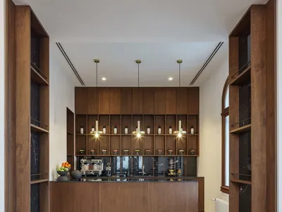 Modern kitchen with wooden cabinets and marble countertops.