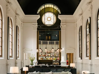 Modern hotel lounge featuring concrete, marble, and leather materials.
