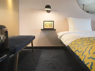 A modern hotel room showcasing an accent light fixture on the wall, providing a warm ambiance.