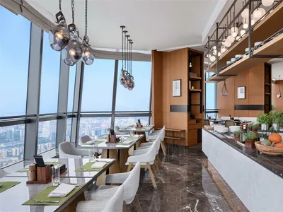 Modern restaurant interior with glass walls, wooden furnishings, and an open floor plan