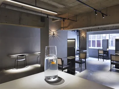 Interior design of a modern restaurant bar with concrete and glass materials.