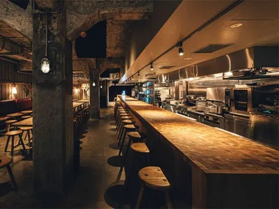 Industrial-style restaurant interior with wooden counter and seating