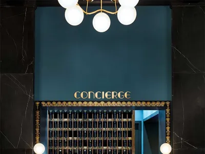 A luxurious hotel concierge desk with a marble countertop and a sign reading 'CONCIERGE'.