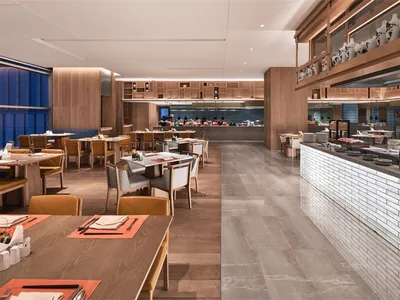 Industrial-themed restaurant buffet area with concrete, wood, and glass materials.