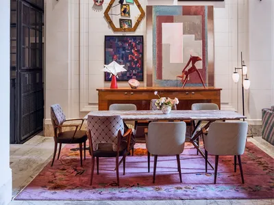 The image depicts a modern restaurant interior with marble flooring, a wooden dining table, upholstered chairs, metal accents