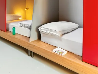 A modern bedroom featuring bunk beds with grey concrete walls.