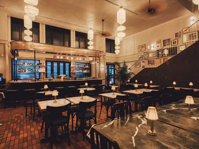 Marble tables and chairs in an industrial-themed restaurant interior