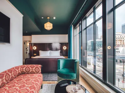 Modern bedroom with fabric furniture, city view, and mixed materials.