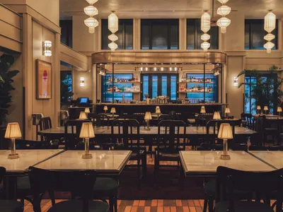 Modern restaurant interior with polished marble tables and concrete accents
