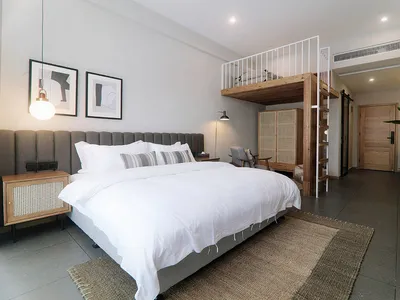A minimalist bedroom featuring wood, concrete, and metal materials