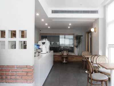 Modern restaurant interior with white walls and a brick-clad coffee counter