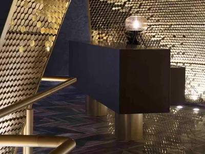 Modern hotel reception area with metallic hexagonal patterns on walls and floors.