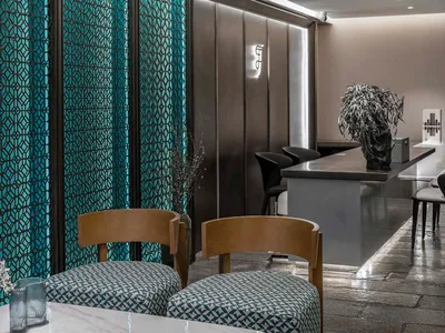 Modern, minimalist restaurant interior with metallic glass panel walls