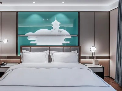 Modern minimalist bedroom with light wooden flooring, white bedding, and a neon light artwork above the bed.