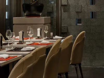 Modern dining room with concrete walls and minimalist furniture.