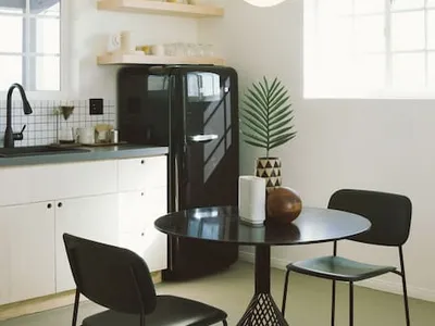 Modern minimalist kitchen featuring concrete countertops and metal furniture.