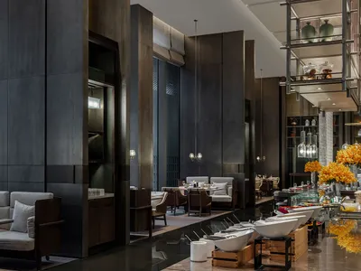 A modern restaurant with concrete, glass, and wooden elements.