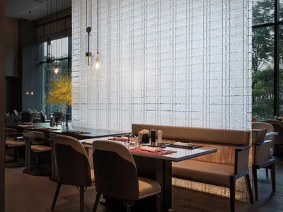 Modern restaurant interior with glass wall and upholstered seating