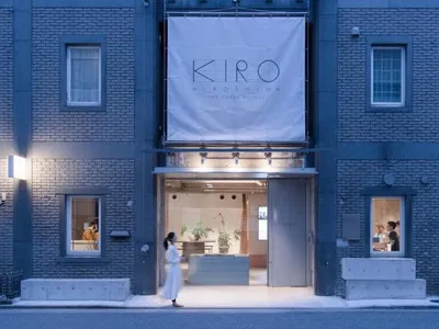 Modern election office entrance with a concrete facade and a sign reading 'Kiro Hiroshima'.