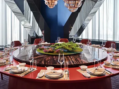 Modern restaurant interior with glass lighting fixtures and a marble dining table.