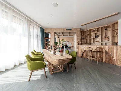 A modern restaurant interior featuring wooden furniture and green accent chairs.