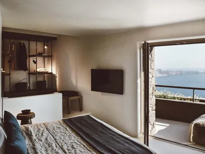 Modern minimalist bedroom featuring concrete, steel, and glass materials.